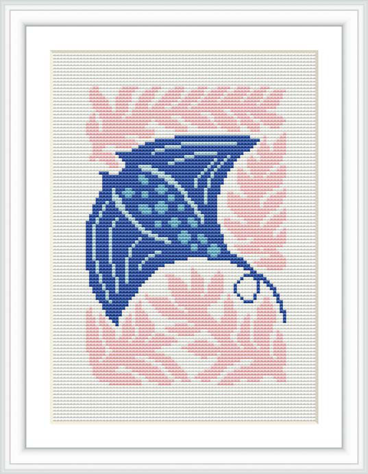 The image showcases a cross stitch pattern depicting a stingray. The stingray is primarily in shades of blue, set against a backdrop of pink coral-like motifs. The pattern is framed within a white border and displayed as if it's in a picture frame.