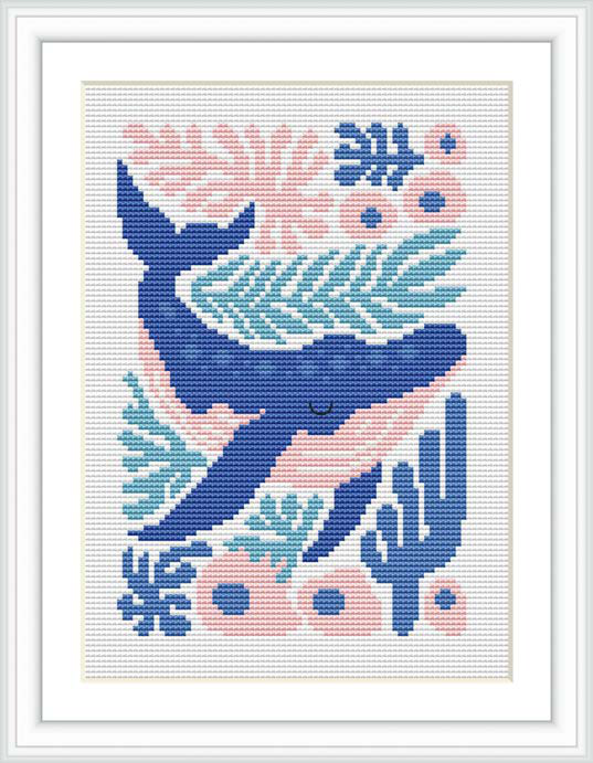The image depicts a cross stitch pattern of a whale swimming in the ocean. The whale is centered in the design, with aquatic plants, coral and bubbles surrounding it. The depiction uses a limited but harmonious color palette.