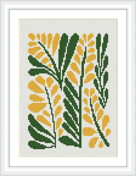The image depicts a cross stitch pattern framed in white, showcasing a design of yellow mimosa flowers with green leaves on a white background.