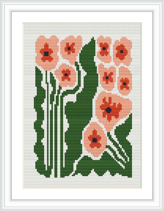 The image depicts a framed cross stitch pattern showcasing a group of pink flowers with prominent green leaves on a white canvas. The flowers are arranged in a stylized manner with a symmetrical layout.