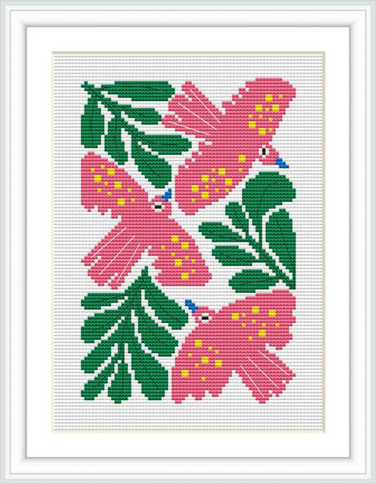 The image depicts a cross stitch pattern showing a pair of stylized birds surrounded by floral elements. The birds are in shades of pink with yellow spots and blue eyes, sitting amongst green foliage with pink flowers.