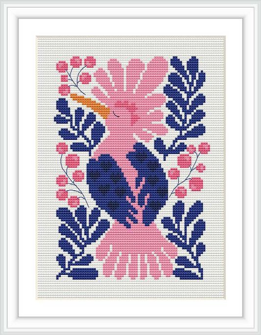 The image shows a cross stitch pattern of a stylized bird centered on the canvas, surrounded by symmetric floral elements. The pattern is rendered in vibrant shades of pink, blue, and yellow, against a white background, and is framed within a simple white frame.