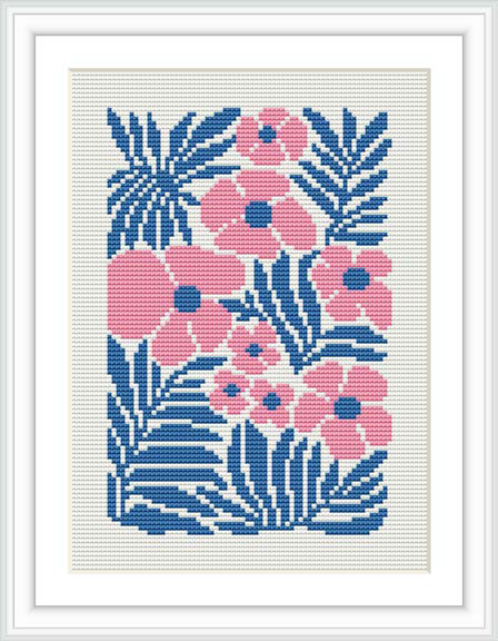 The image showcases a framed cross stitch pattern featuring stylized blue and pink flowers and foliage against a white background.