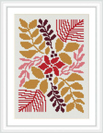 The image showcases a framed finished cross stitch design. The pattern displays a collection of stylized flowers and leaves, predominantly in shades of red, gold, and pink, artistically arranged against a white background.