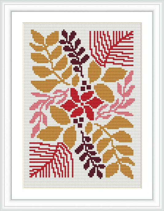 The image showcases a framed finished cross stitch design. The pattern displays a collection of stylized flowers and leaves, predominantly in shades of red, gold, and pink, artistically arranged against a white background.