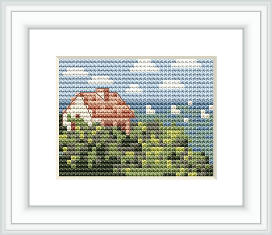 The image depicts a cross stitch pattern of a house surrounded by lush greenery with an ocean and sky in the background. The house has a red roof, and the sea shows different shades of blue.