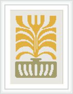 A symmetrical cross stitch pattern featuring a stylized plant with broad leaves emerging from an ornate vase. The design uses a limited color palette, predominantly in shades of gold and green, framed with a white border.