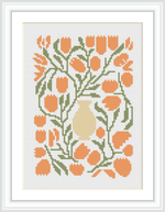 The image shows a cross stitch pattern of a cream-colored vase with a bouquet of orange tulips surrounded by green foliage, encased within a white border and framed.