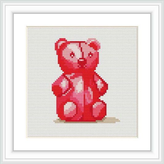 The image displays a framed cross stitch pattern of a cartoonish red bear sitting down against a white background with shadowing beneath it.