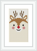 The image displays a framed cross stitch pattern of a stylized deer face with antlers. The design is centered on a light background fabric, positioned within a minimalist white frame.