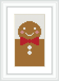 The image features a framed cross stitch pattern of a smiling gingerbread man with cheeks, eyes, and a bow tie in red and pink, centered on a piece of fabric.