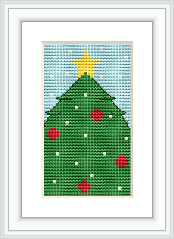 The image shows a framed cross stitch pattern of a simple Christmas tree with red ornaments on a green tree, a yellow star on top, and small white accents, resembling snowflakes, set against a lightly patterned blue background.