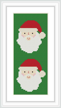 The image displays a framed cross stitch bookmark with a pattern of two Santa Claus faces stacked vertically. Each Santa has a cheerful expression, a red hat, and a white beard against a green background.