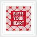 The image shows a cross stitch design framed in white, featuring the phrase 'BLESS YOUR HEART' centered on a red background, with a pattern of white hearts and diamonds decorating the border area.