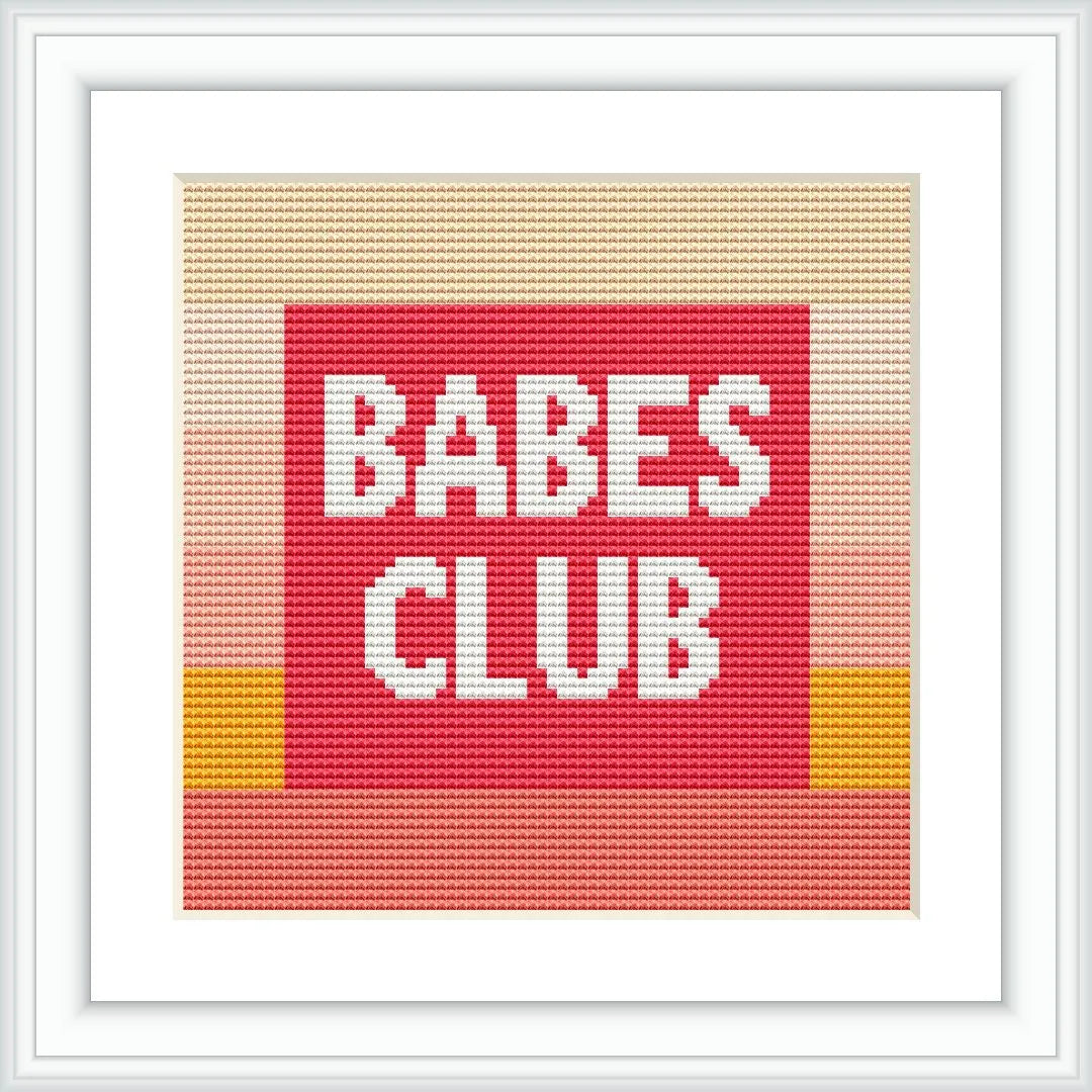 The image displays a framed cross stitch pattern featuring the phrase 'BABES CLUB' in block capital letters centered on a red background with a top and bottom border of yellow, pink, and beige stripes.