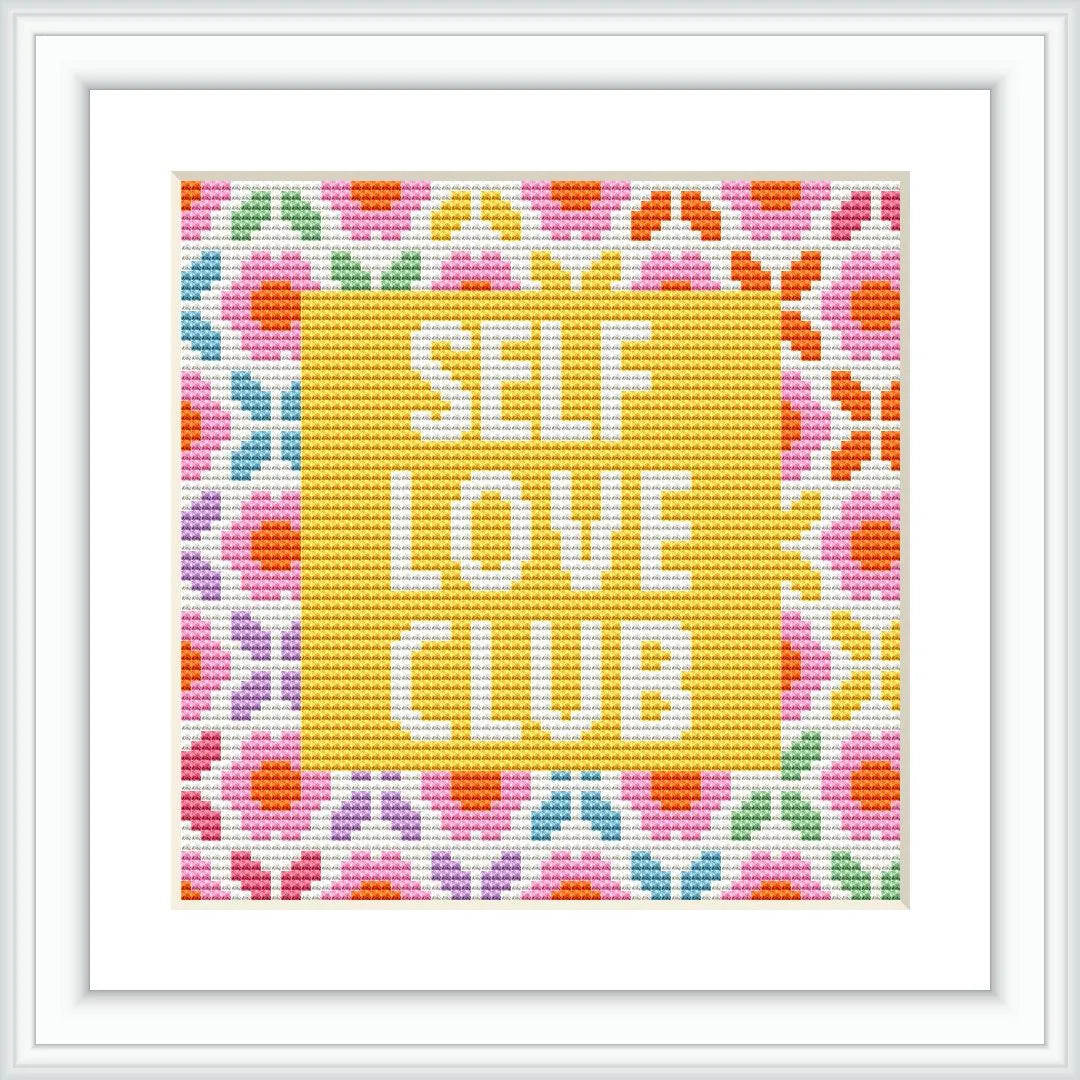 The image shows a cross stitch pattern that reads 'SELF LOVE CLUB' in block letters centered on a yellow background, surrounded by a heart-shaped floral border with multiple colors.