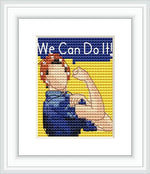 The image displays a framed cross stitch pattern showing a woman flexing her arm muscle, resembling the iconic Rosie the Riveter 'We Can Do It!' poster. It features a blue background with yellow accents.