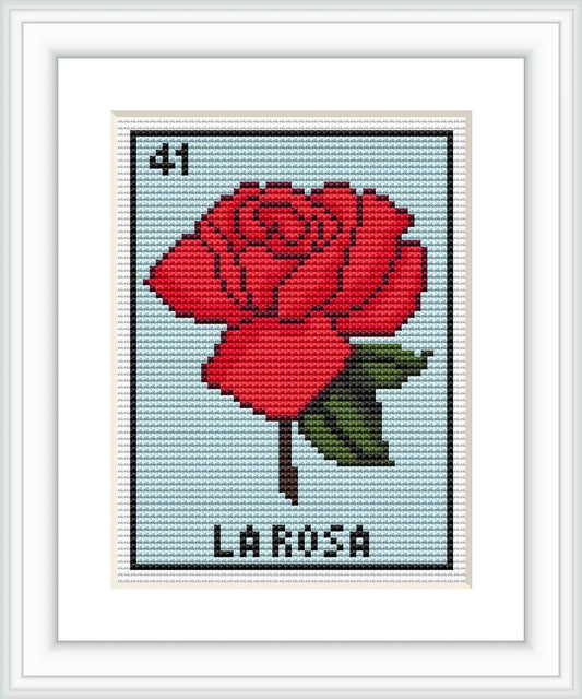 The image shows a cross-stitch pattern of a red rose with green leaves centered on a blue background, resembling a Lotería game card, with the number '41' at the top and 'LA ROSA' at the bottom.