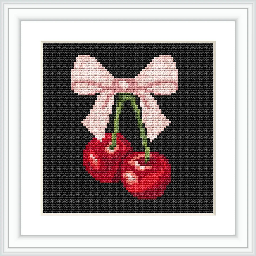 The image depicts two red cherries with attached green stems, tied together by a pink bow, centered on a black background within a white square frame.